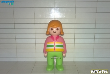 Девочка с рыжими волосами в салатовых брюках и розовой рубашке с желтыми белыми и салатовыми полосами